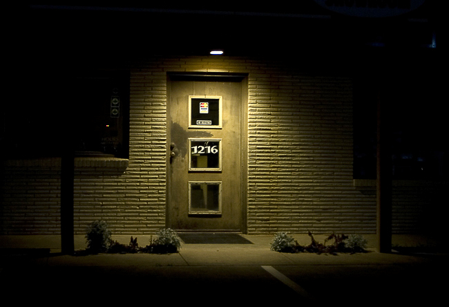 10 Things Every Local Business Can Do To Improve Their SEO image of business front door at night with spotlight shining down over entrance